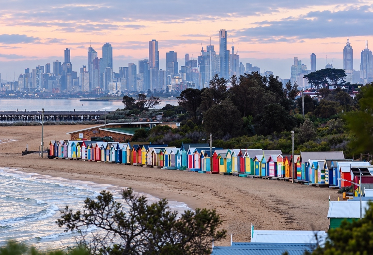 Brighton Beach bathing boxes with the Melbourne skyline across Port Phillip Bay